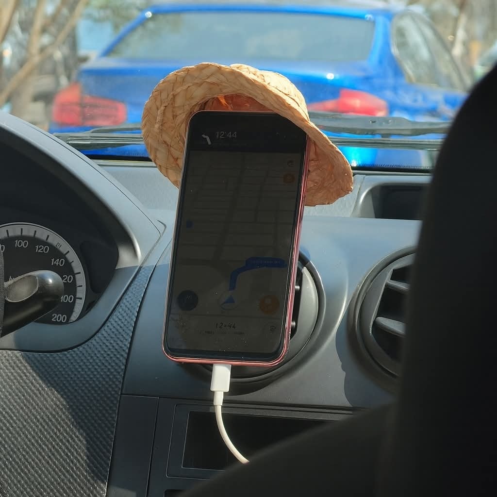 Telefón pred palubnou doskou s malým klobúčikom nad obrazovkou.