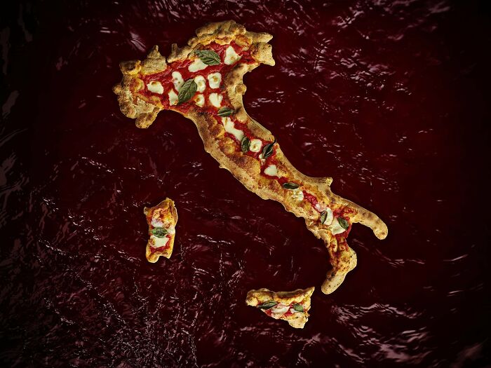 Mapa Talianska vo forme pizze na tmavom pozadí s bazalkou a mozzarellou.