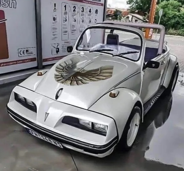 Biele retro auto s otvorenou strechou a jedinečným orlím motívom na kapote.