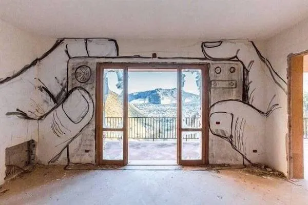 Mural rúk držiacich fotoaparát, cez ktorý je vidieť malebná horská krajina za veľkými francúzskymi oknami.