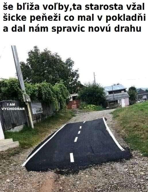 Úzky asfaltový pás na nespevnenej ceste, ironický text o volebnej kampani.