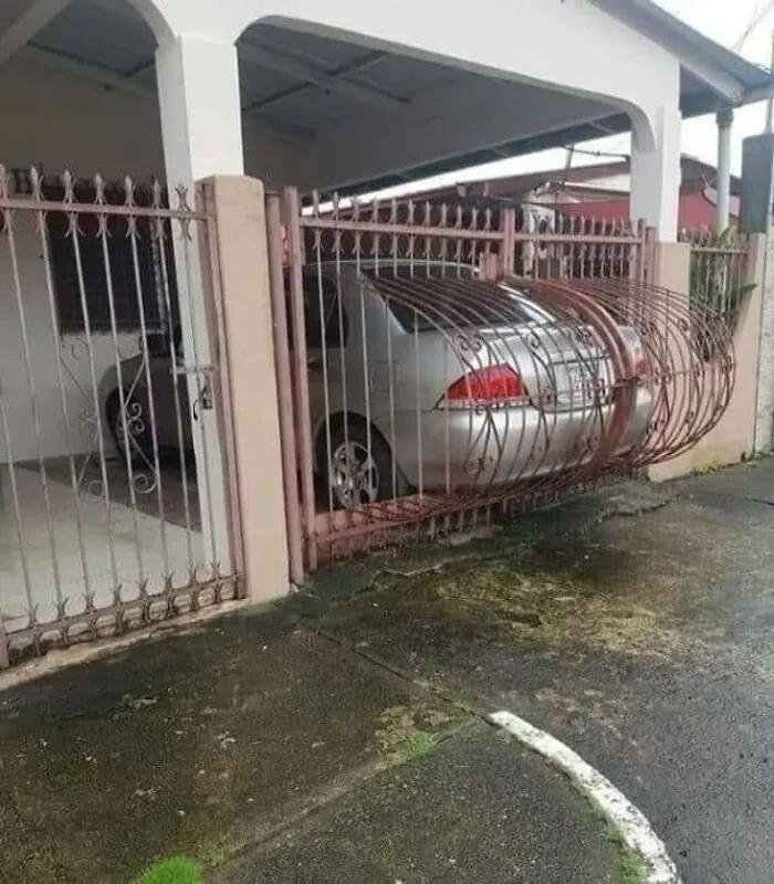 Auto zachytené v kovovej bráne, ktorá sa ohla smerom von. Parkovanie vyžadujúce opravy.