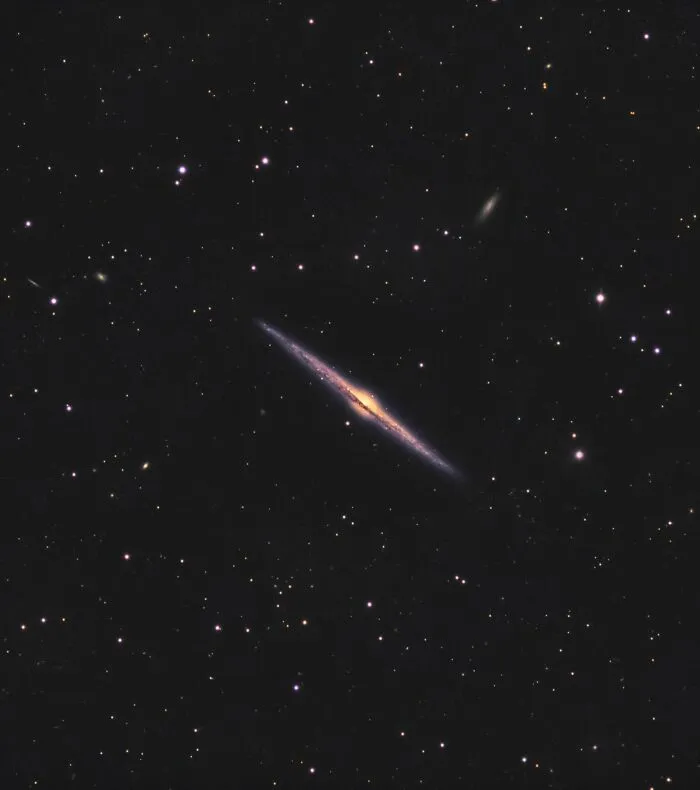 Špirálová galaxia NGC 4565 s diskovým tvarom a žiarivým jadrom na hviezdnej oblohe.