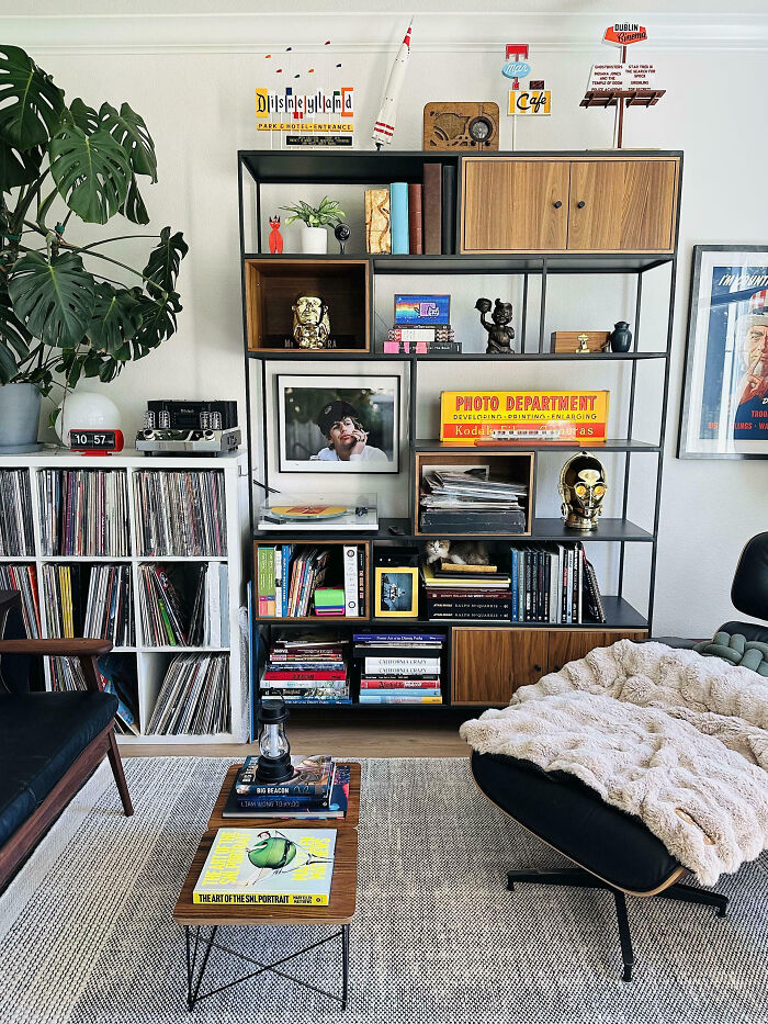 Moderný interiér obývačky s vinylmi, knižnicou a dekoráciami, ktorý vytvára útulnú atmosféru.