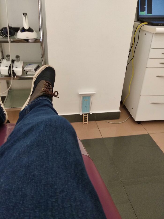 Osoba sedí v izbe a pozoruje maličké dvere s rebríkom na stene, ako v rozprávke pre myši.