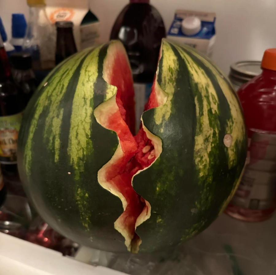 Melón s výraznou prasklinou odhaľujúcou červenú dužinu.
