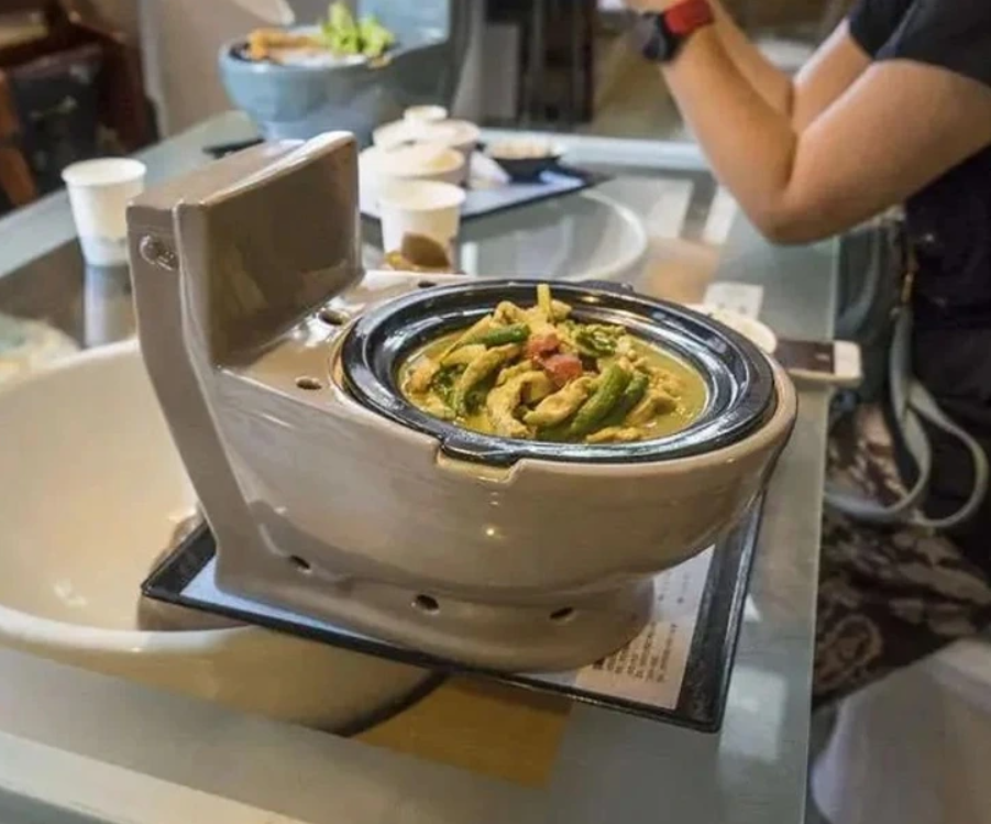 Bizarné servírovanie jedla v miske v tvare toalety, kreatívny gastronomický zážitok v nezvyčajnej reštaurácii.