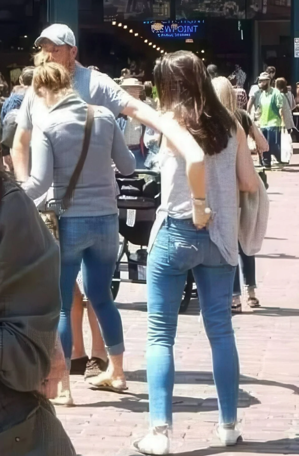 Skupina ľudí na preplnenej ulici v slnečnom počasí.
