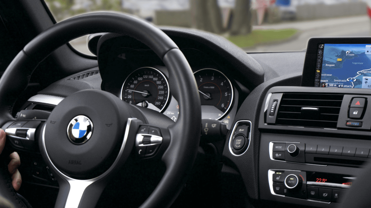 Interiér automobilu s navigáciou na displeji a pohľadom na volant a prístroje.