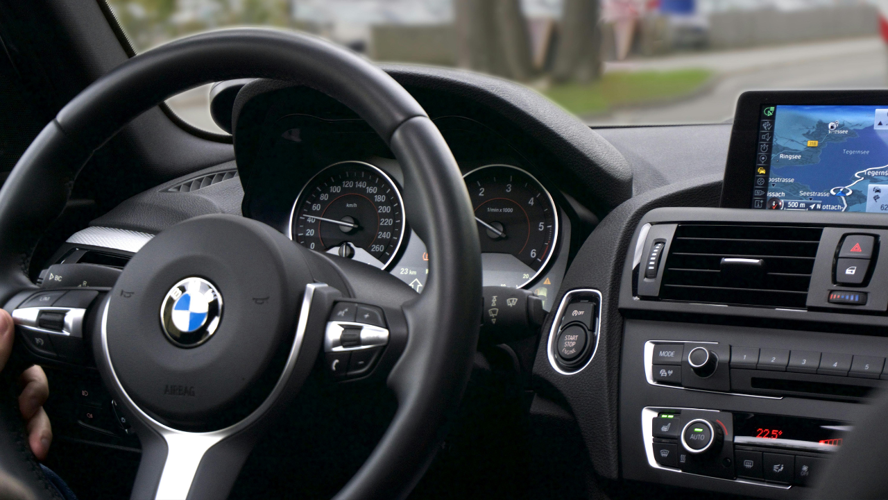 Interiér automobilu s navigáciou na displeji a pohľadom na volant a prístroje.
