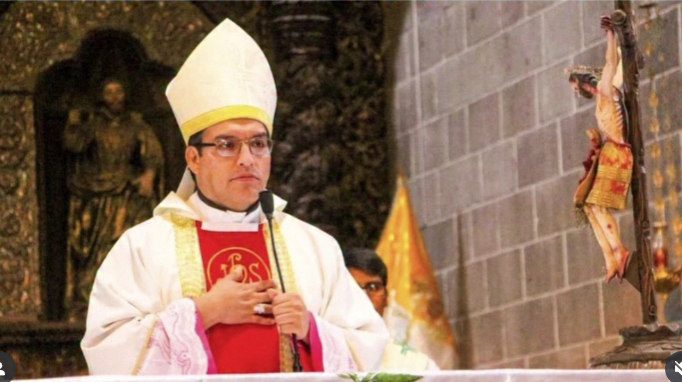 Osoba v liturgickom rúchu pred krížom v kostole, vyzerá, akoby sa modlila počas obradu.