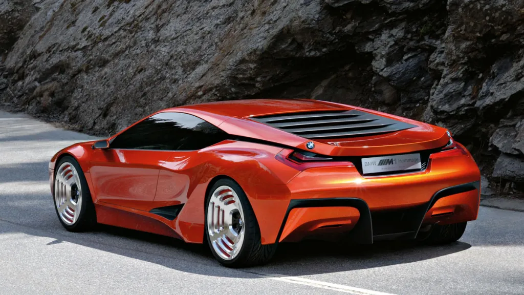 Futuristické oranžové športové auto na horskej ceste, v pozadí skalnatý terén.