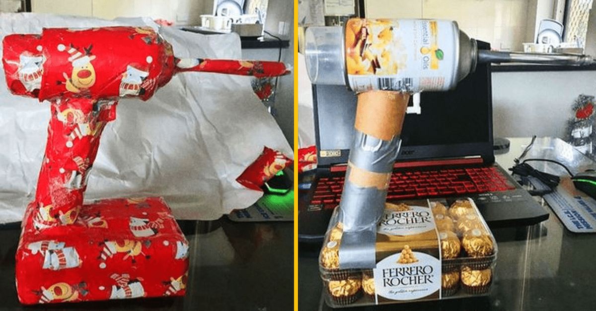 Vtipný DIY darček, vianočne zabalená vŕtačka z plechovky na čokoládach Ferrero Rocher, položená na notebooku.