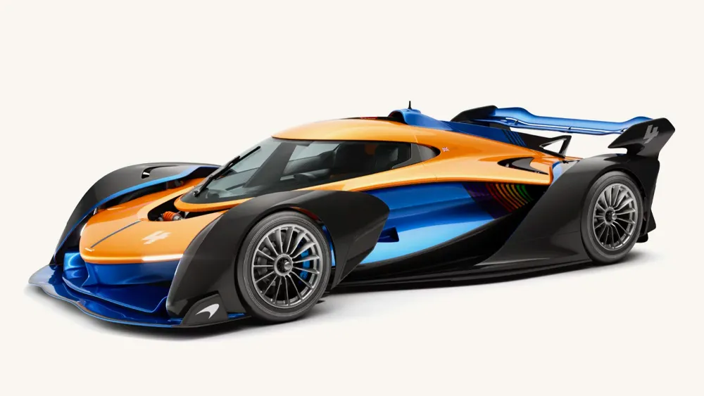 Oranžovo-modrý športový superauto s aerodynamickým dizajnom a veľkým zadným krídlom na bielom pozadí.