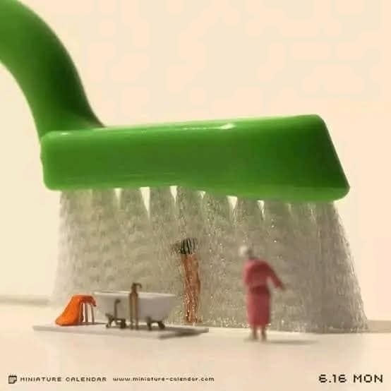 Miniatúrne figúrky si užívajú sprchu pod veľkou kefou vo vtipnom zobrazení každodennej hygieny.