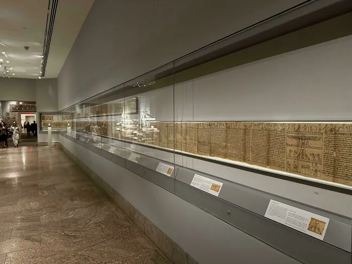 Expozícia starovekého papyrusu za sklom v múzeu, detail historických textov na chodbe.