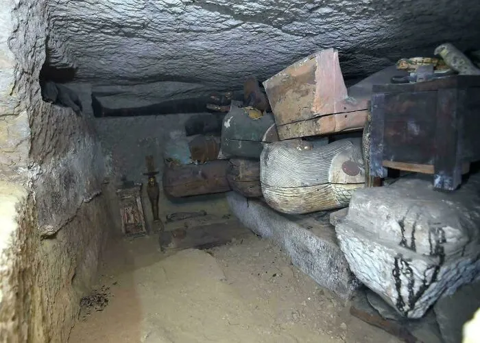 Staroveká hrobka s artefaktmi a pozostatkami v úzkej podzemnej komore z odkrytia pri archeologickom prieskume.