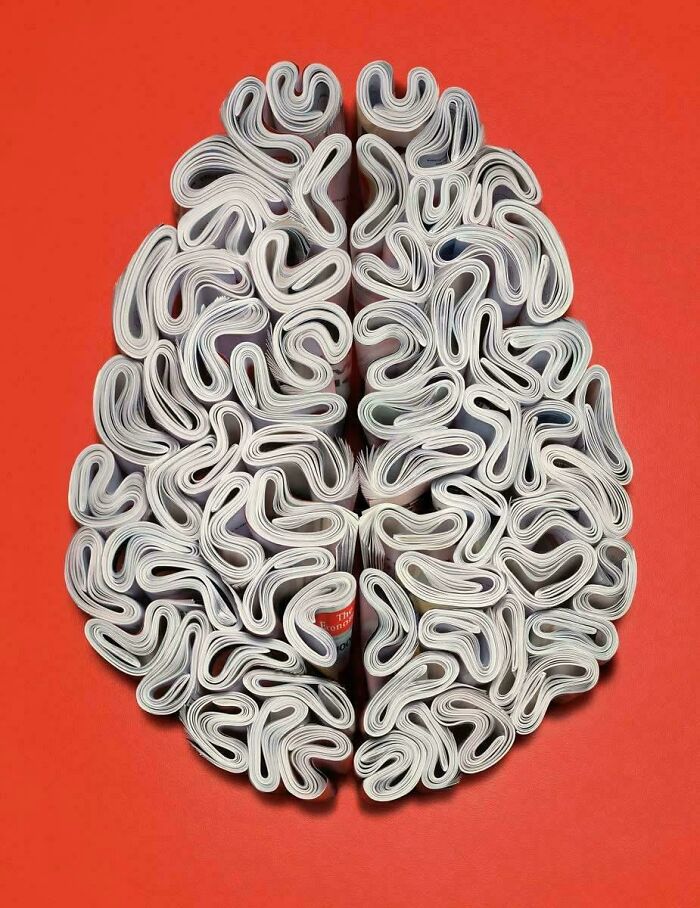Spletené časopisy vytvárajú tvar mozgu na červenom podklade, symbolizujúce kreativitu a informácie.