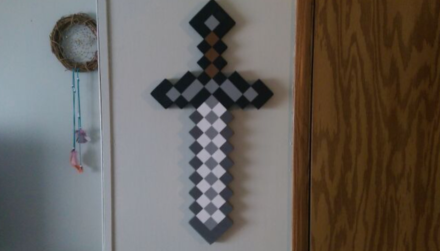 Pixlový meč z hry Minecraft vystavený na stene vedľa lapača snov.