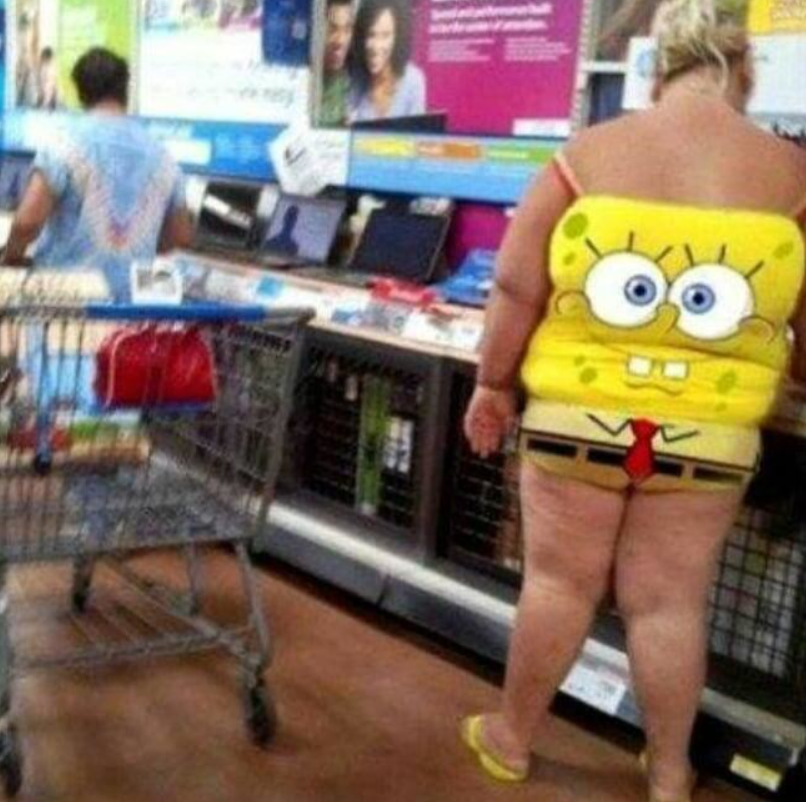 Osoba v obchode s oblečením s potlačou Spongeboba na chrbte, nákupný vozík v popredí.