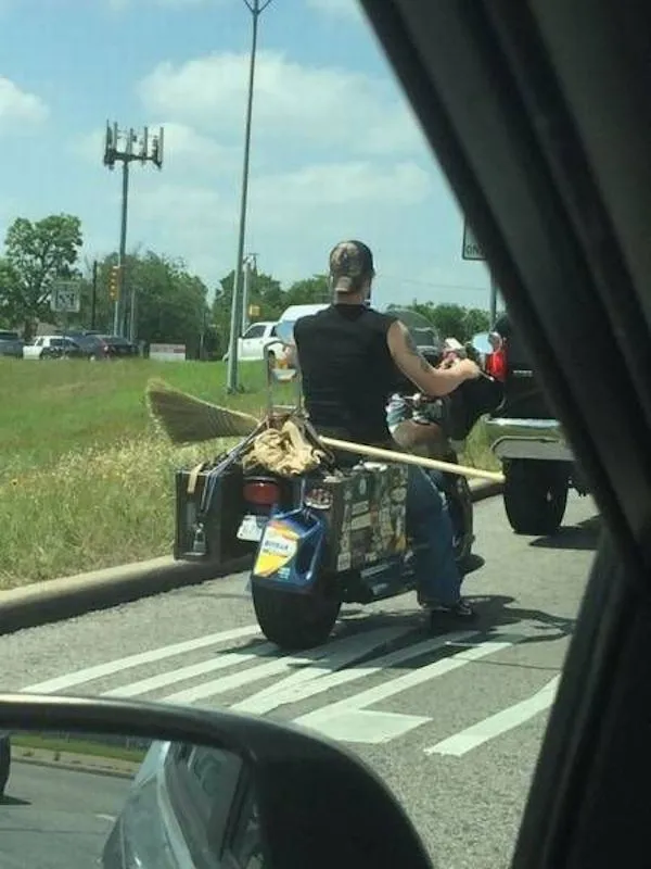 Muž na motorke s pripevnenou metlou, jazdiaci po ceste.