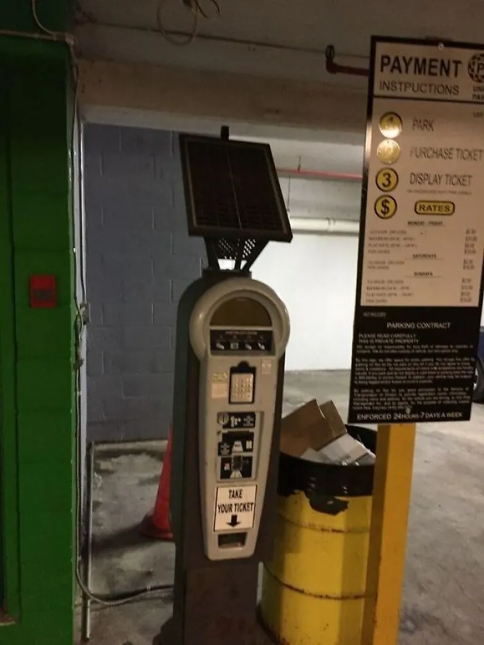 Parkovací automat s návodom na použitie v garáži, pripravený vydať vstupenky.