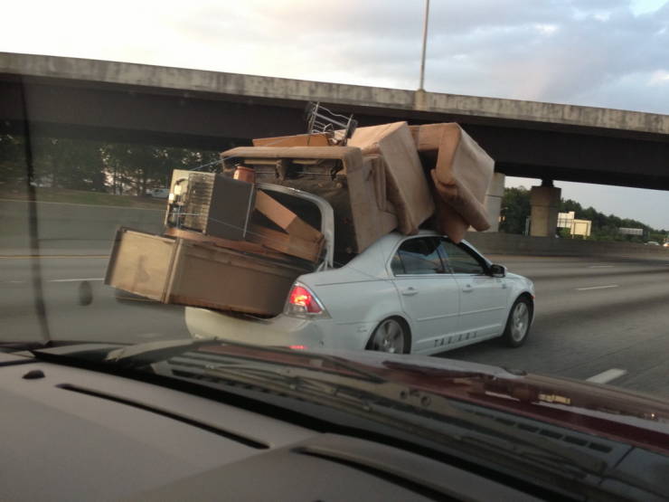 Auto preťažené nábytkom na diaľnici, nebezpečný transport bez zabezpečenia pod mostom.