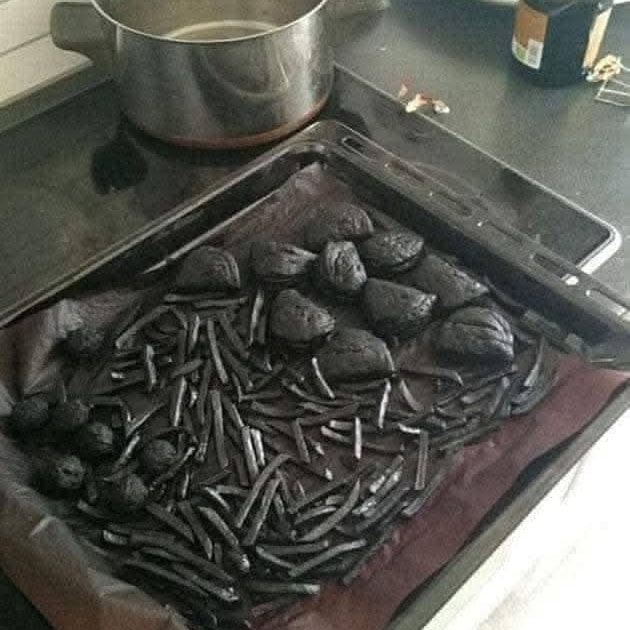 Spálené hranolky a kuracie nugety na plechu v kuchyni, nepodarený pokus o varenie.