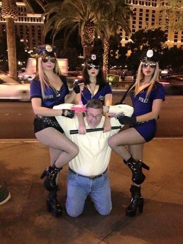 Muži a ženy v kostýmoch policajtov na ulici v nočnom meste.