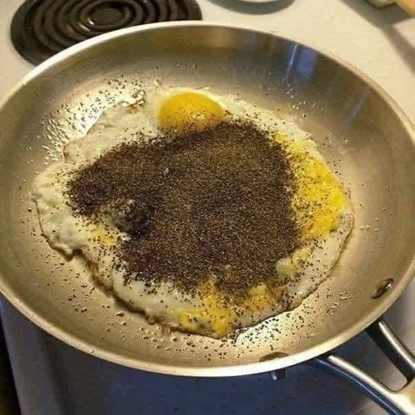 Vajíčko na panvici bohato posypané mletým čiernym korením.