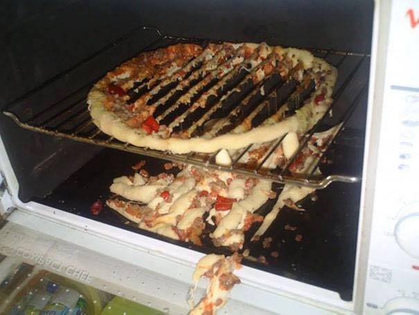 Pizza katastrofa: chybne položené cesto v rúre, rozpadajúce sa cez mriežku s ingredienciami všade naokolo.