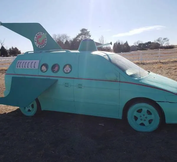 Modifikované auto v štýle vesmírnej lode Planet Express na vidieckej ceste, inšpirované televíznym seriálom Futurama.