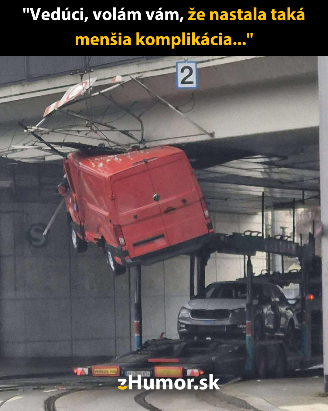Nákladné auto zaseknuté pod mostom so zdvihnutou plošinou na prepravu vozidiel, spôsobená nehoda.