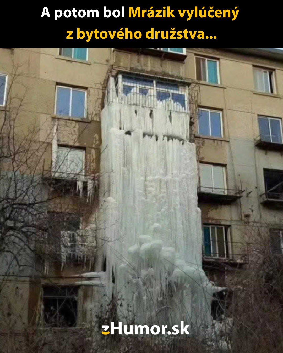 Ľadový stĺp na fasáde bytového domu po zamrznutí strechy.