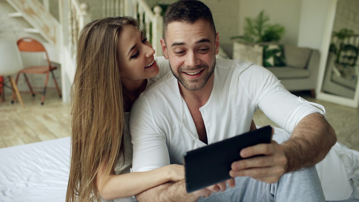 Couple looking at a tablet together with smiles