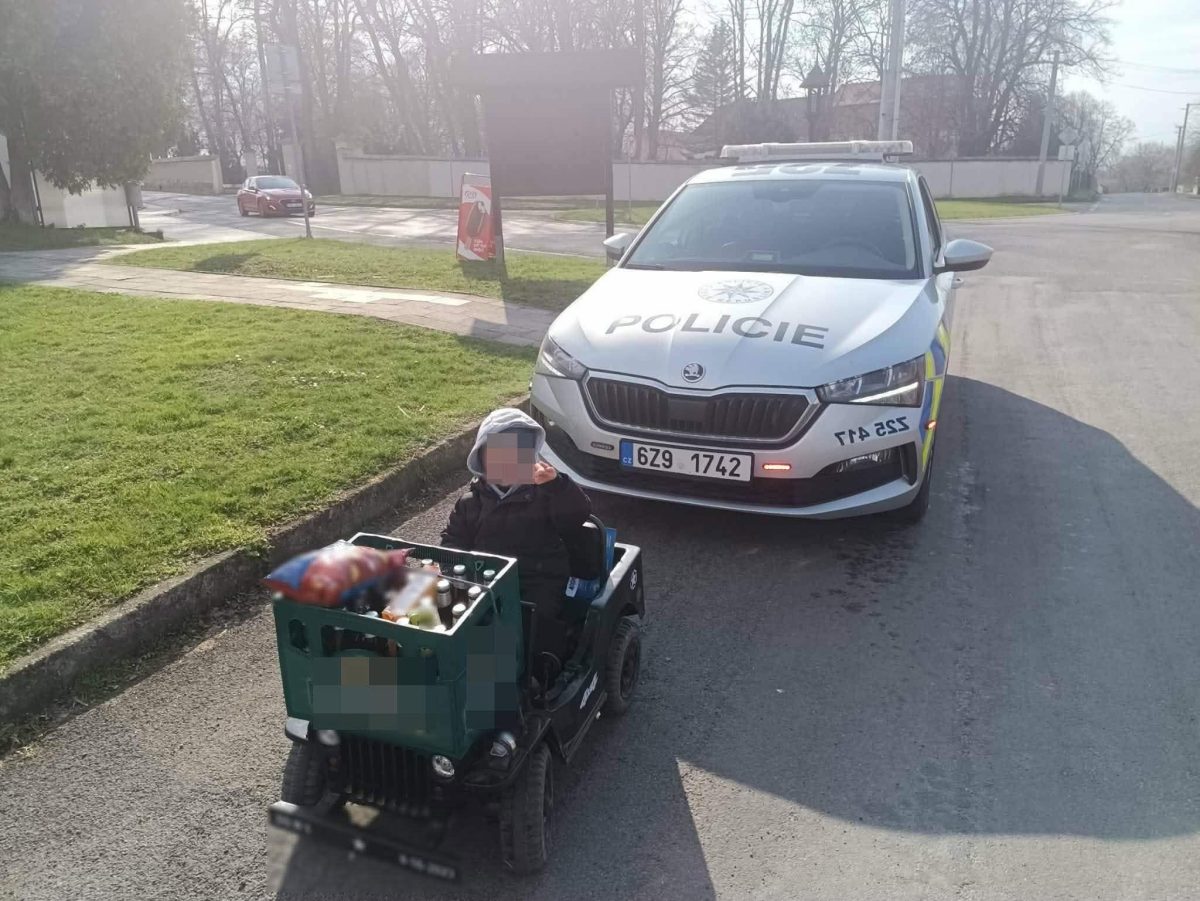 Dieťa na motokáre zastavené policajným autom na ceste. Polícia v akcii na kontrolu poriadku.