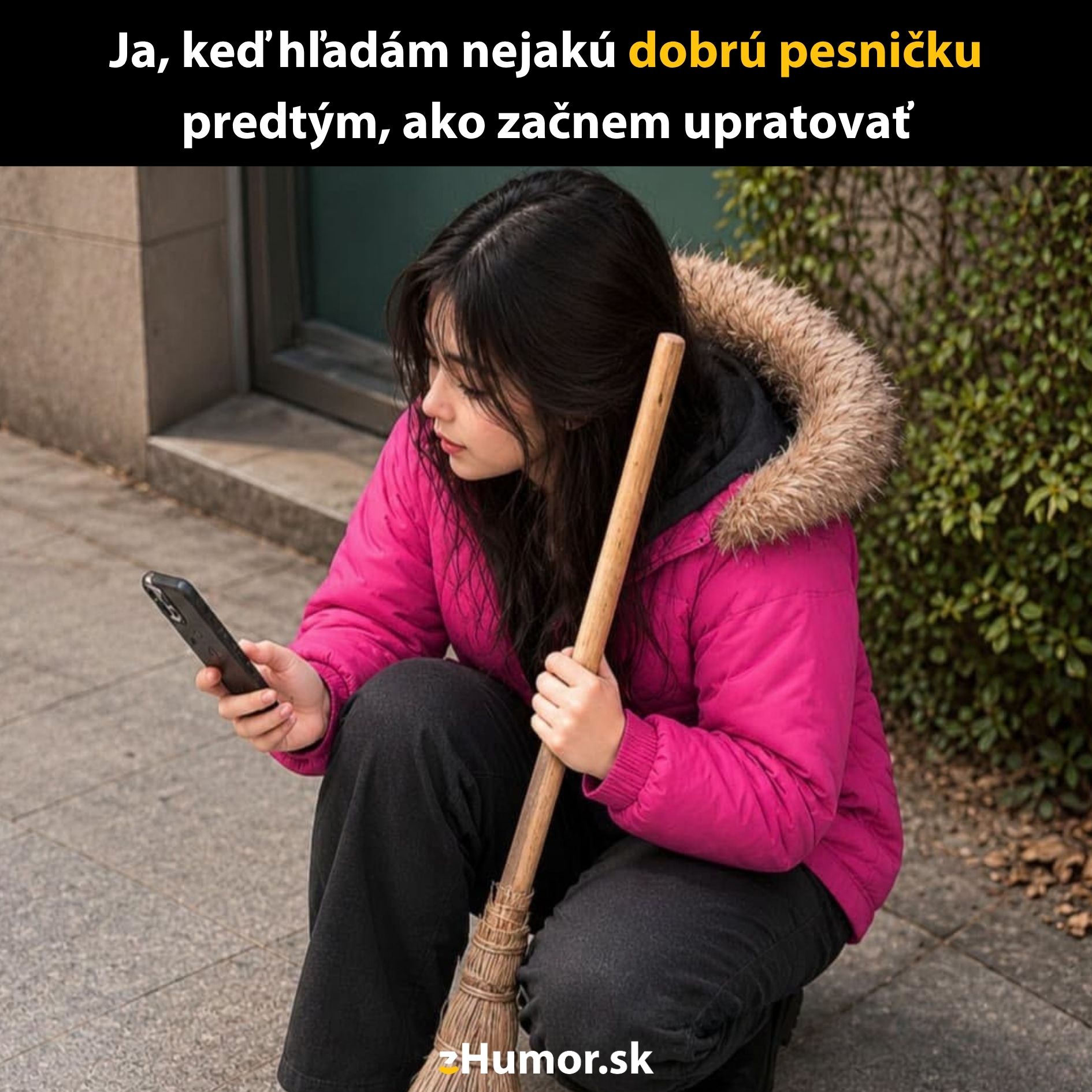 Osoba v ružovej bunde so smartfónom a metlou, pripravená upratovať po výbere dobrej pesničky.