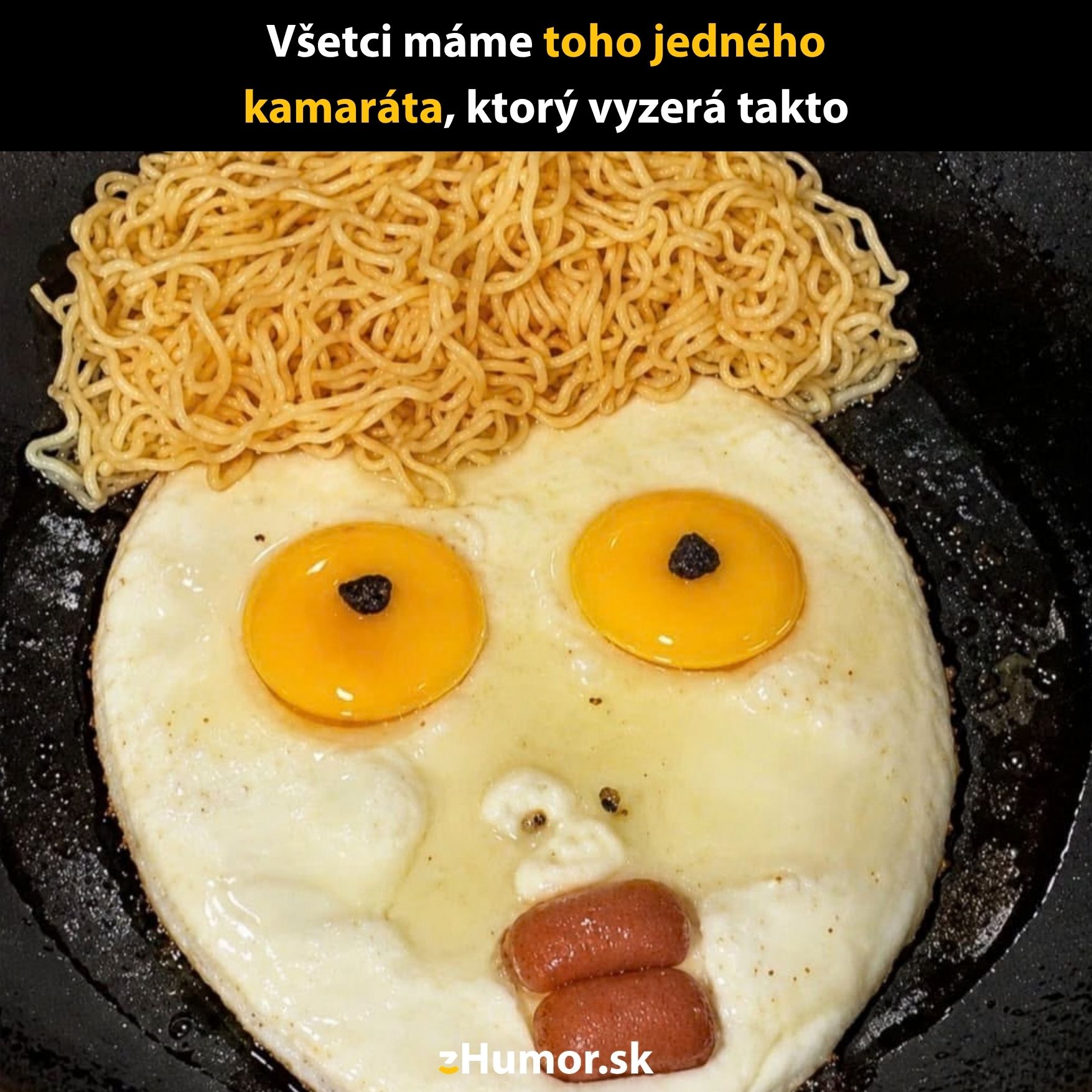 Vtipná tvár z vajec a rezancov na panvici, pripomínajúca karikatúru s výraznými očami a kučeravými vlasmi.
