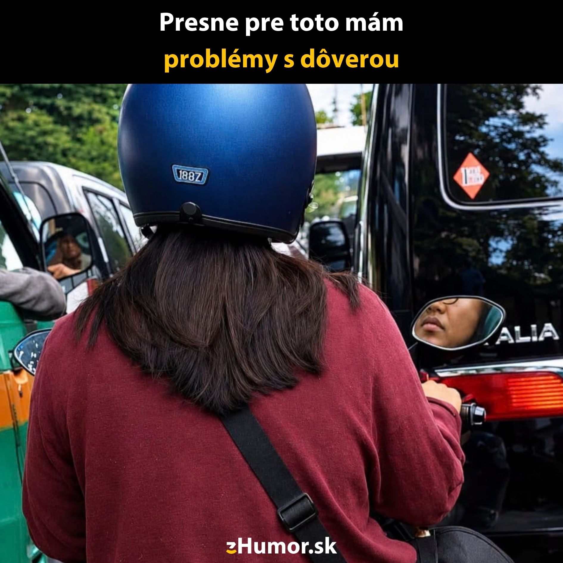 Motorkárka so spätným zrkadlom ukazujúcim tvár pasažiera v idúcom aute. Humor o dôvere na cestách.